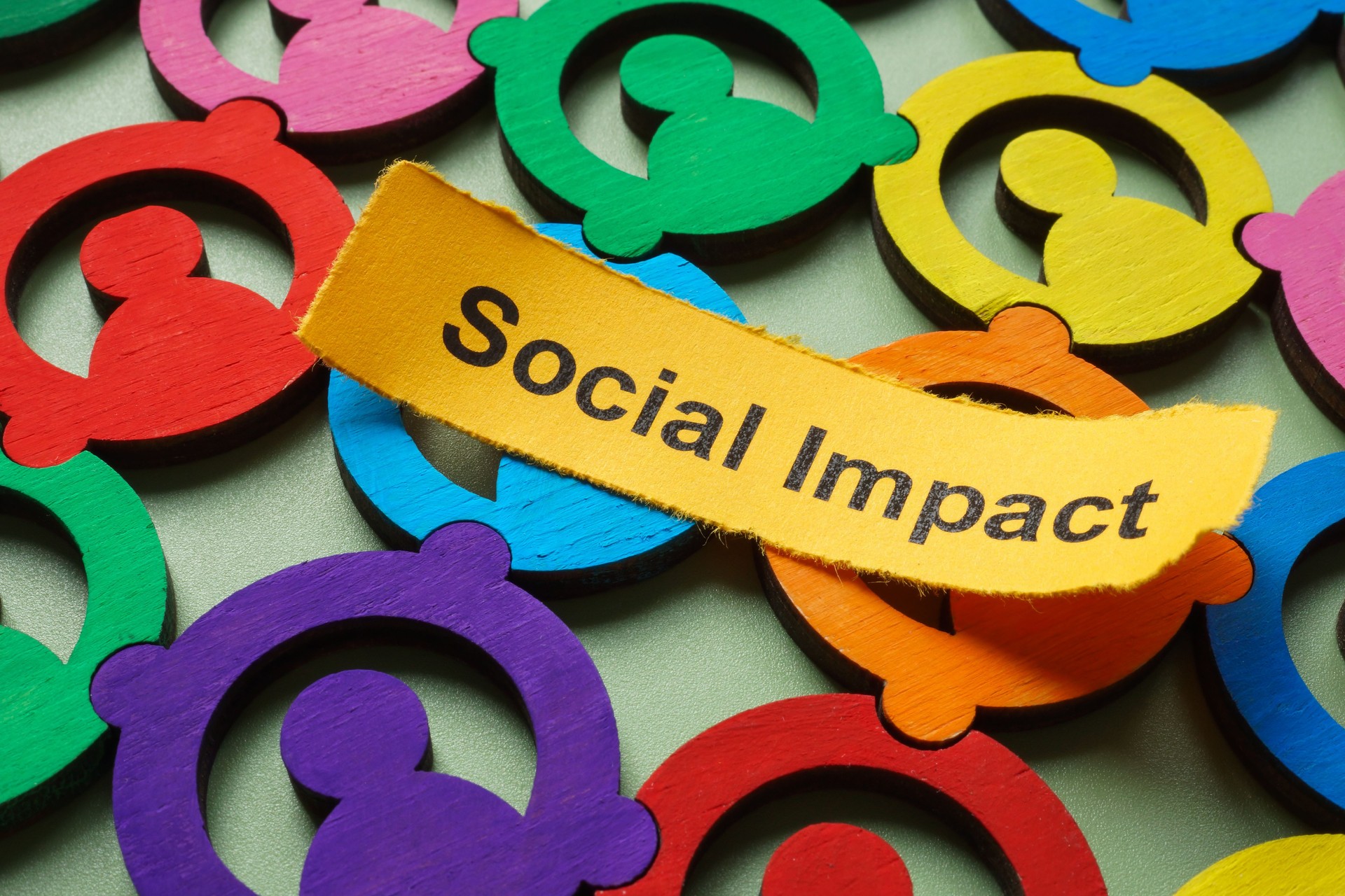 Bunte Figuren und das Wort Social Impact. Vielfalt und Community-Entwicklung.
